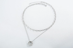 Macro view of silver double-layer chain necklace with interlocking triple ring pendants