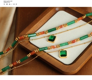 Dettaglio collana doppia vintage con perline verdi e ciondolo con taglio a smeraldo