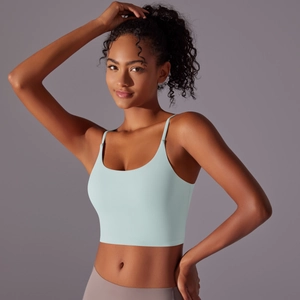 Detail view of mint green yoga crop top featuring thin straps and wide ribbed hem