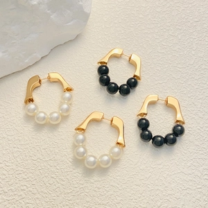 Detail of vintage French style gold hoop earrings with white pearls and black beads