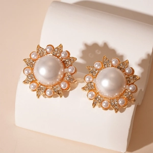 Close-up of baroque pearl sunflower earrings with crystal pavé and golden metal details