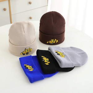 Detail of soft knitted beanies for boys with colorful embroidered excavator patterns