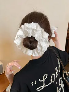 Close-up of a white double-layer lace scrunchie with intricate embroidery details