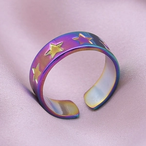 Gros plan sur la bague ajustable en acier inoxydable arc-en-ciel aux motifs d'étoiles