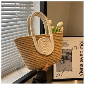 Detail of hand-woven cotton rope tote bag in beige with white round braided accents