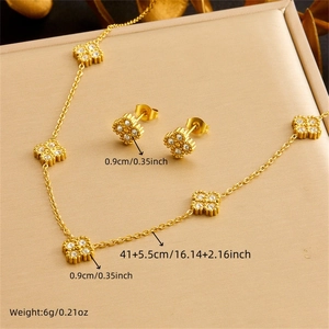 Nahaufnahme von vergoldetem Kleeblatt-Schmuckset mit Zirkonia-Kristallen und Maßen