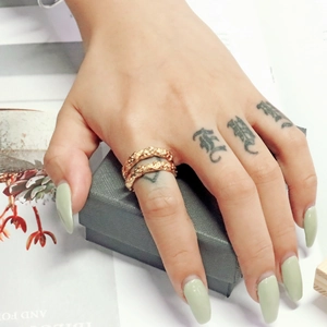Detail eines vergoldeten Rings mit Seilstruktur, getragen am Finger im Vintage-Stil