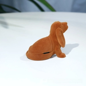 Detailed side view of brown puppy-shaped flocked ring box with velvety texture and hinge