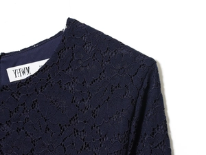 Macro detail of navy blue floral lace fabric with matching lining and fine stitching