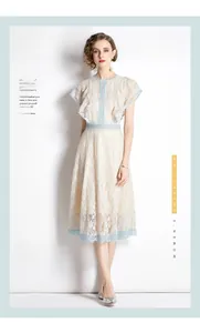 Detail of light blue floral lace trim and beige fabric on elegant midi dress