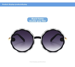 Front view of round flower petal sunglasses with black frame and gradient gray lenses