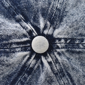 Detail shot of the acid-washed denim baseball cap showing heavy twill fabric and stitching