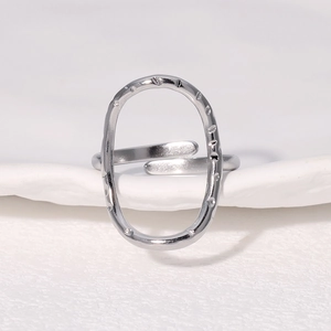 Minimalist silver hammer-textured oval hollow stainless steel open ring on white decor