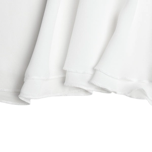 Close-up of white chiffon dress hem showing fine double-needle stitching and fabric texture