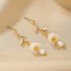 Elegant 18K gold flower earrings with marquise zircon and pearl drop on beige fabric