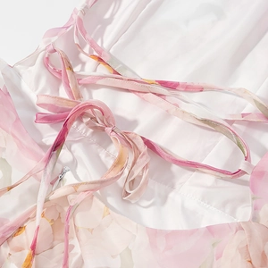 Detailansicht der Rückseite eines Blumenkleides mit rosa Schnürung und Reißverschluss