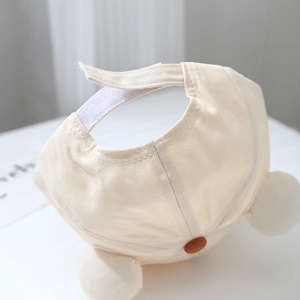 Detail of adjustable velcro strap and plush pom-pom on toddler baseball cap