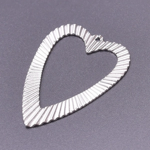 Macro detail of heart pendant accessory with striped texture in silver finish