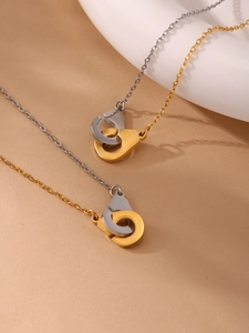 Détail de colliers avec pendentifs menottes bicolores en placage or et argent