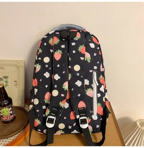 Detailed back view of a black strawberry print backpack showing anti-theft zipper pocket