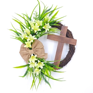 Macro detail of Easter cross wreath with rustic burlap bow and white lily flowers