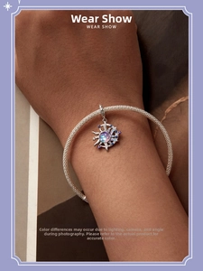 Detail eines s925 Silber-Anhängers mit Sonne und Mond an einem geflochtenen Armband