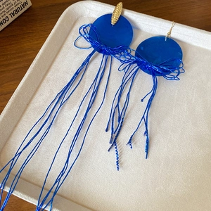 Gros plan détaillé de boucles d'oreilles à franges bleu vintage et détails dorés