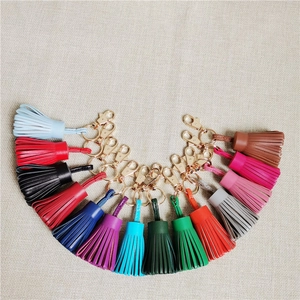 Macro shot of colorful leather tassels with gold metal lobster clasps on linen texture