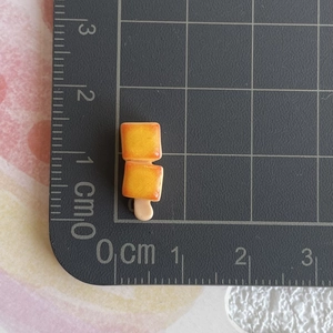Mini breloque alimentaire en résine avec mesures sur un tapis de découpe