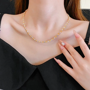 Detail of 18k gold and silver two-tone beaded necklace on model's neck for luxury look