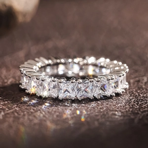 Macro detail of princess cut stones in a classic silver eternity ring setting