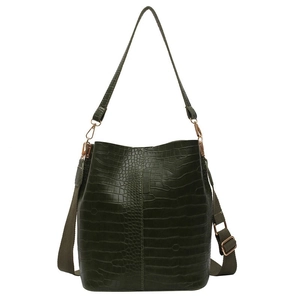 Dark green crocodile pattern bucket bag with a wide woven shoulder strap on white background