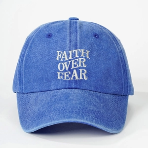 Detail of high-quality white embroidery FAITH OVER FEAR on blue washed cotton baseball cap