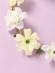 Macro detail of hand-woven floral wreath headband with white and yellow fabric flowers