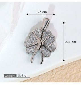 Macro shot showing 1.7cm width and 2.6cm height of a zircon-set four-leaf clover pendant