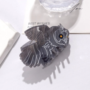Detailed view of the owl-shaped acetate hair claw clip with intricate feather patterns