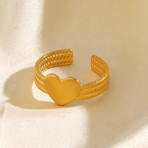 Bague coeur dorée élégante avec anneau à trois rangs texturés sur satin beige