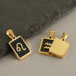 Stainless steel 18k gold zodiac pendants featuring Leo and Aquarius symbols on fabric