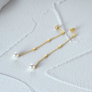 Detail of s925 silver tassel earrings with white pearl and gold finish butterfly clasp