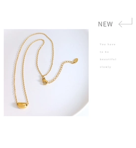 Detail of gold bean pendant necklace with adjustable chain and lobster clasp