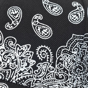 Close-up of white paisley print on black twill fabric for a stylish baseball cap detail