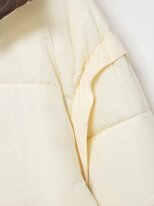 Detail view of cream white puffer jacket showing quilted stitching and windproof fabric