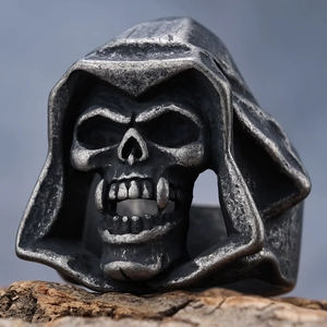 Detailed macro shot of vintage skull cloak ring in oxidized silver finish on wood