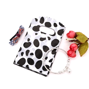 Detail view of mini plastic gift bags with cow print pattern and integrated handle
