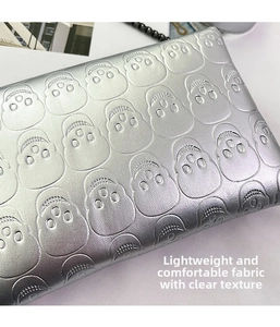 Detail of silver skull embossed leather envelope bag with clear metallic grain texture