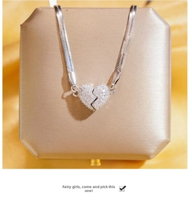 Detail view of silver snake chain necklace with a heart pendant encrusted in zircon stones