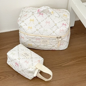 Détails d'un ensemble de trousses de maquillage matelassées à motifs de nœuds floraux