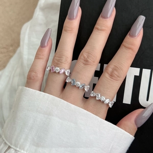 Detail of silver S925 rings with pink, blue, and white zircon gemstones on model hand