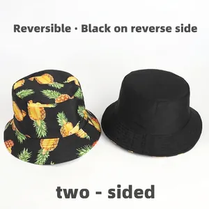 Double-sided bucket hat featuring tropical pineapple print and solid black versatile design