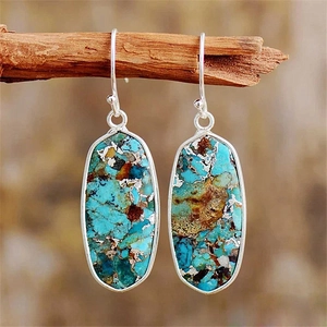 Macro shot of bohemian teardrop earrings featuring natural blue-green emperor stones